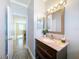 Bathroom vanity with marbled countertop, dark cabinets, and a view into another room at 1602 Presidio Dr, Clermont, FL 34711