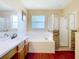 Bathroom showcasing a tub and shower with stone accents and a vanity with wood cabinets at 1602 Presidio Dr, Clermont, FL 34711