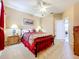 Comfortable bedroom with neutral carpet, ceiling fan, and view into another room and access door at 1602 Presidio Dr, Clermont, FL 34711