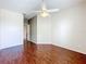 Spacious bedroom boasting hardwood floors and a ceiling fan, leading to an attached room at 1602 Presidio Dr, Clermont, FL 34711
