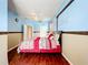 Large bedroom featuring light blue accent walls, wood floors, and ample natural light at 1602 Presidio Dr, Clermont, FL 34711