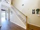 Inviting foyer with wood-look tile flooring and staircase leading to the upper level of the home at 1602 Presidio Dr, Clermont, FL 34711