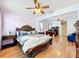 Spacious main bedroom featuring hardwood floors, comfortable bed, ceiling fans, and an office area at 1602 Presidio Dr, Clermont, FL 34711