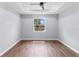 An airy bedroom features hardwood floors, a modern ceiling fan, and a bright window at 1765 9Th Ave, Deland, FL 32724