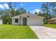 Inviting single-story home with a well-manicured lawn and convenient two-car garage at 1765 9Th Ave, Deland, FL 32724