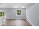 Bright living room featuring a modern tray ceiling, window and wood-look flooring at 1765 9Th Ave, Deland, FL 32724