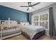 Cozy bedroom with a ceiling fan, a large window, and a bed and crib with white bedding at 2035 Dixie Belle Dr # 2035C, Orlando, FL 32812