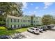 Green apartment building with black shutters, a well-manicured lawn, and ample parking on a sunny day at 2035 Dixie Belle Dr # 2035C, Orlando, FL 32812