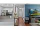 Hallway with hardwood floors leading to kitchen and living area with an accent wall and television at 2035 Dixie Belle Dr # 2035C, Orlando, FL 32812