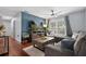 A living room with hardwood floors, a blue accent wall, a sectional sofa, and a ceiling fan at 2035 Dixie Belle Dr # 2035C, Orlando, FL 32812