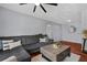 Inviting living room featuring hardwood floors, a gray sofa, a decorative mirror, and a ceiling fan at 2035 Dixie Belle Dr # 2035C, Orlando, FL 32812