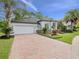 Front elevation with a brick-paved driveway and lush landscaping at 2342 Northumbria Dr, Sanford, FL 32771