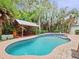 Inviting pool with spa and covered outdoor entertaining area surrounded by lush tropical landscaping at 2342 Northumbria Dr, Sanford, FL 32771
