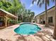 Inviting pool with covered patio and outdoor entertaining area surrounded by lush tropical landscaping at 2342 Northumbria Dr, Sanford, FL 32771