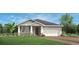 Charming single-story home featuring a two-car garage, landscaped yard, and stylish architectural details at 2727 Arbor Dune Ave, Apopka, FL 32712