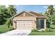 Inviting single-story home featuring a two-car garage, lush landscaping, and a welcoming entryway at 2921 Elio Hammock Dr, St Cloud, FL 34773