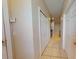 Bright hallway featuring neutral walls, tile flooring, and white closet doors, creating a clean and airy transition space at 3552 Macauley Ct, Ocoee, FL 34761