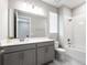 Well-lit bathroom showcasing a vanity, shower-tub combo, and neutral tilework at 4028 Southern Vista Loop, St Cloud, FL 34772