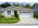 Contemporary one-story home featuring a two car garage, light stucco, stone accents, and well-maintained landscaping at 4028 Southern Vista Loop, St Cloud, FL 34772