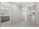 Hallway with tile floors leading to a bathroom with gray cabinets and multiple bedrooms at 4028 Southern Vista Loop, St Cloud, FL 34772