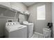 Laundry room with washer, dryer, shelving, and window for natural light at 4028 Southern Vista Loop, St Cloud, FL 34772