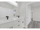 Bathroom with dual sinks, a large mirror, white cabinets, and a doorway at 4662 Sw 136Th St, Ocala, FL 34473