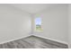 Bright bedroom with gray vinyl flooring and a large window showcasing the outdoors at 4662 Sw 136Th St, Ocala, FL 34473