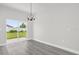 A modern dining room features gray floors, slider doors to the yard, and a modern chandelier at 4662 Sw 136Th St, Ocala, FL 34473