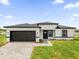 A modern home features a two car garage, gray brick paver driveway, and manicured lawn at 4662 Sw 136Th St, Ocala, FL 34473