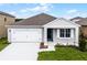 Charming single-story home featuring a two-car garage, a welcoming front porch, and a well-maintained lawn at 5162 Marshelder St, Apopka, FL 32712
