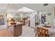 Bright eat-in kitchen featuring white cabinets, an island, and a dining area with a large window at 7040 Betty St, Winter Park, FL 32792