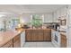 Well-lit kitchen with white appliances, wooden cabinets, and an open layout at 7040 Betty St, Winter Park, FL 32792