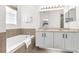 Bright bathroom with dual sinks, large mirror and bathtub at 7416 Soiree Way, Reunion, FL 34747