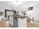 Open kitchen with black countertops, island, tile floor, and stainless steel appliances at 7416 Soiree Way, Reunion, FL 34747