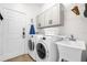 Functional laundry room with washer, dryer, sink, and storage cabinets at 7416 Soiree Way, Reunion, FL 34747