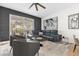 Elegant living room with a large window, dark accent wall, modern furniture, and stylish decor at 7416 Soiree Way, Reunion, FL 34747