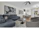Modern living room with grey sofa, contemporary artwork, and adjacent dining area with seating for eight at 7416 Soiree Way, Reunion, FL 34747