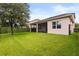 Spacious backyard featuring a lush lawn, mature tree, and a black metal fence at 1046 Grand Hilltop Dr, Apopka, FL 32703