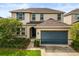 Charming two-story home with a two-car garage, manicured landscaping, and neutral stucco at 1046 Grand Hilltop Dr, Apopka, FL 32703