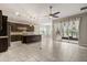 Modern kitchen with dark wood cabinets, tile backsplash, island with sink, and an open floorplan to a dining area with sliding glass doors at 1046 Grand Hilltop Dr, Apopka, FL 32703