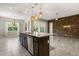 Granite-top kitchen island, wood cabinets, stainless steel dishwasher, plus stone accent wall & windows with coverings in spacious design at 1046 Grand Hilltop Dr, Apopka, FL 32703