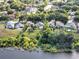An aerial shot showcases homes backing up to a serene lake surrounded by abundant greenery and trees at 1108 Summer Lakes Dr, Orlando, FL 32835