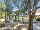 Charming two-story green home featuring an attached two-car garage, columned front window, and lush trees at 1108 Summer Lakes Dr, Orlando, FL 32835