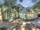 Lovely two-story green home featuring an attached two-car garage, columned front window, and dark roof at 1108 Summer Lakes Dr, Orlando, FL 32835