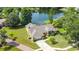 Aerial view of home with pool, lush landscaping, and lake view at 1125 Almond Tree Cir, Orlando, FL 32835