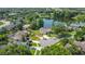 Aerial view of the home with lush landscaping, and a serene lake backdrop at 1125 Almond Tree Cir, Orlando, FL 32835
