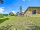 Expansive backyard showcasing the home, screened lanai, and mature landscaping, perfect for outdoor living at 1125 Almond Tree Cir, Orlando, FL 32835