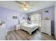 Comfortable bedroom with a window view, ceiling fan, wood flooring, and soft lavender color at 1125 Almond Tree Cir, Orlando, FL 32835
