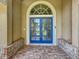 Close-up of beautiful blue double doors with glass panels and an arched transom window at 1125 Almond Tree Cir, Orlando, FL 32835