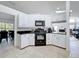 Charming kitchen with white cabinets, black appliances, and a view of the adjacent dining and living areas at 1125 Almond Tree Cir, Orlando, FL 32835